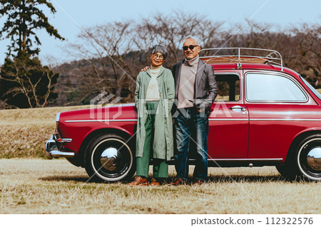 Photo of a stylish senior couple standing with their favorite car 112322576