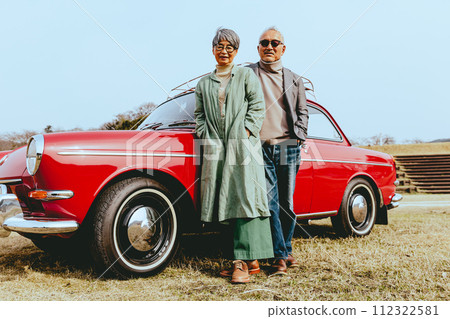 Photo of a stylish senior couple standing with their favorite car 112322581