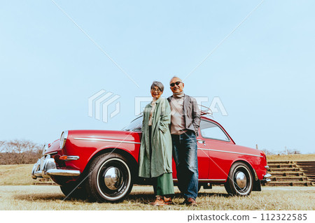 Photo of a stylish senior couple standing with their favorite car 112322585