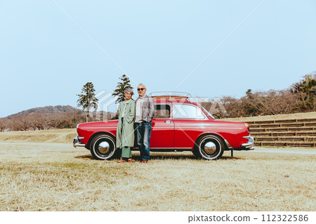 一對時髦的老年夫婦站在他們最喜歡的車旁的照片 一對時髦的老年夫婦站在他們最喜歡的車旁的照片 112322586