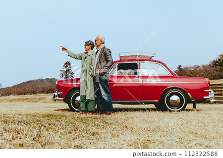 一對時髦的老年夫婦站在他們最喜歡的車旁的照片 一對時髦的老年夫婦站在他們最喜歡的車旁的照片 112322588