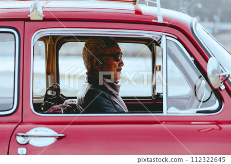 A picture of a senior man driving in his car 112322645