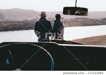 Photo of a senior couple holding hands at sunset 112322665