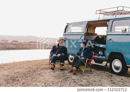A senior couple sitting on an outdoor chair in the dusk 112322712