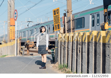 A high school girl standing on the railroad tracks 112322950