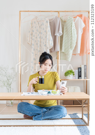 Young woman eating breakfast in the living room 112323199