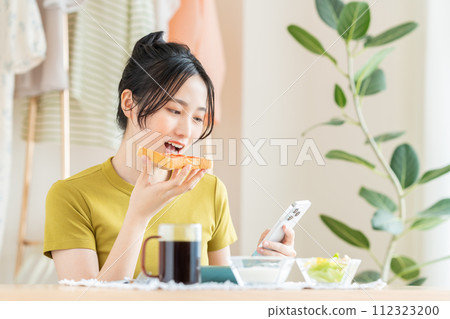 Young woman eating breakfast in the living room 112323200