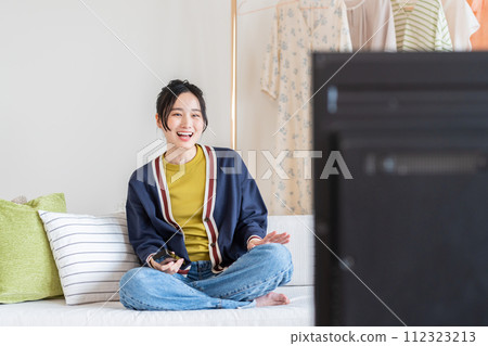 A young lady watching TV in the living room A young lady watching TV in the living room 112323213