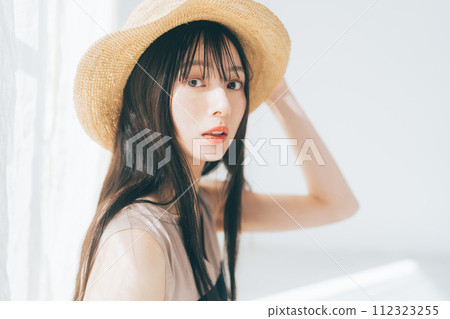 Woman with long hair wearing a straw hat 112323255