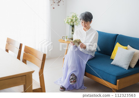 在客廳讀書的高級婦女 112323563