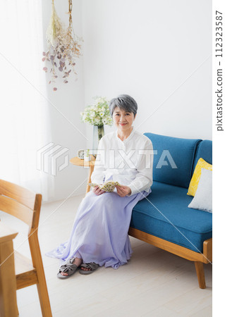 Senior woman reading in the living room Senior woman reading in the living room 112323587