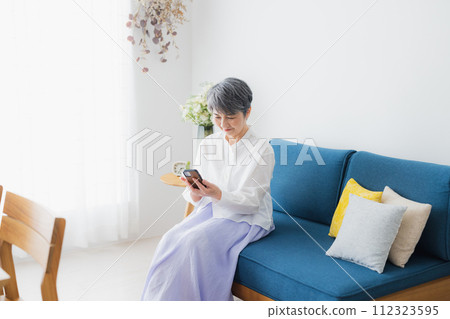 Senior woman looking at her smartphone 112323595