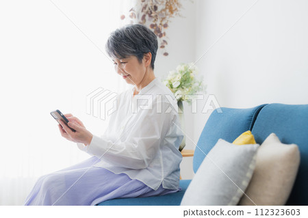 Senior woman looking at her smartphone Senior woman looking at her smartphone 112323603
