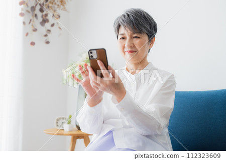 Senior woman looking at her smartphone Senior woman looking at her smartphone 112323609
