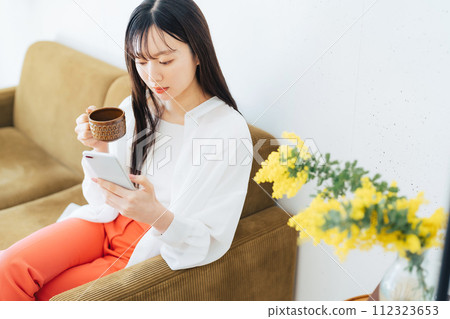 A young woman operating a smartphone 112323653