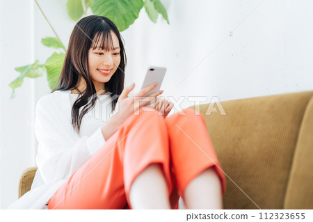 一個操作智能手機的年輕女子 112323655