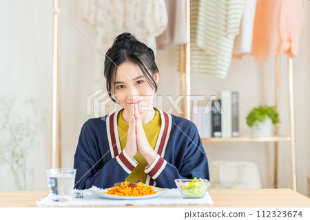 年輕女子在客廳裡吃麵食 112323674