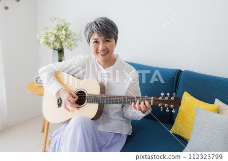 Senior woman playing the guitar 112323799
