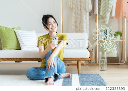 Young woman looking at her smartphone in the living room 112323893