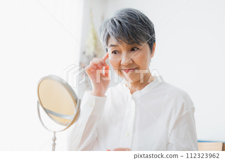 Senior woman reading in the living room 112323962