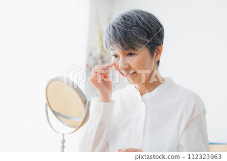 Senior woman reading in the living room 112323963