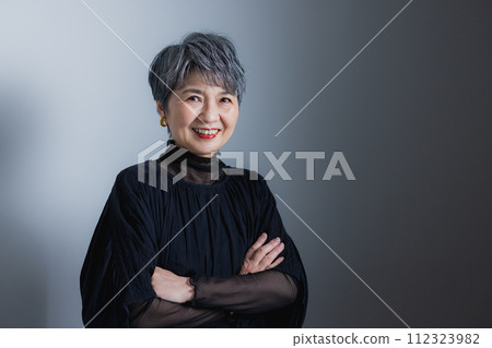 Senior woman smiling and folding arms 112323982