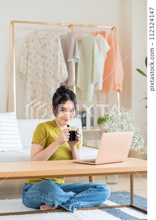 使用一台電腦在客廳裡的年輕女子 112324147