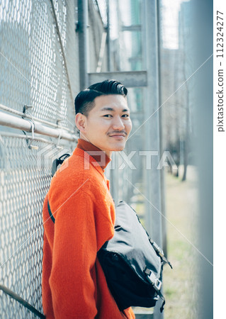 man leaning on fence 112324277