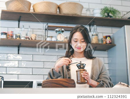 Woman making coffee in the kitchen Woman making coffee in the kitchen 112324391