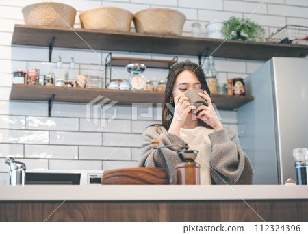 在廚房喝咖啡休息的女人 在廚房喝咖啡休息的女人 112324396