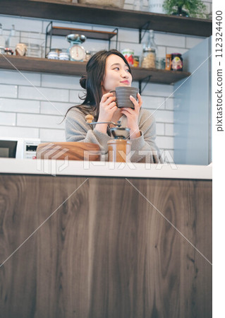 在廚房喝咖啡休息的女人 112324400