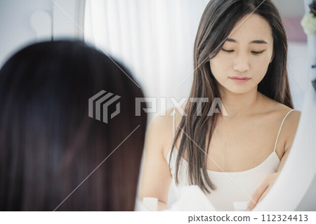 照鏡子做皮膚護理的年輕女性 112324413