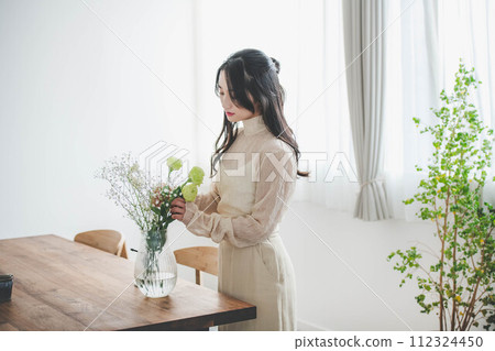 Lifestyle image of a young woman who arranges flowers 112324450