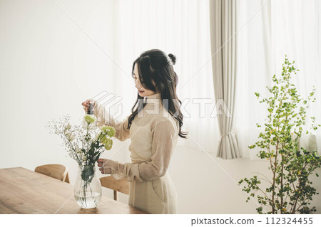 Lifestyle image of a young woman who arranges flowers Lifestyle image of a young woman who arranges flowers 112324455