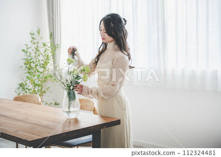 Lifestyle image of a young woman who arranges flowers 112324481
