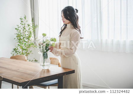 Lifestyle image of a young woman who arranges flowers 112324482