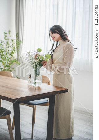 Lifestyle image of a young woman who arranges flowers 112324483