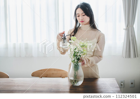 Lifestyle image of a young woman who arranges flowers 112324501