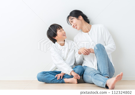 父母和孩子靠著白牆放鬆 112324802