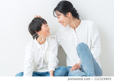 父母和孩子靠著白牆放鬆 112324803