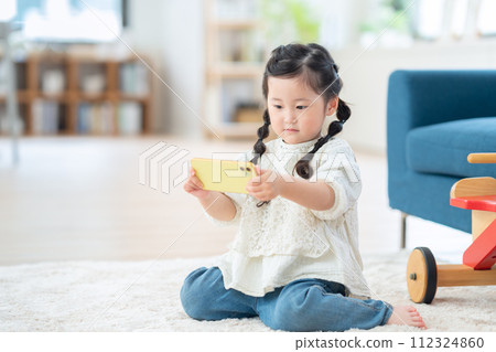 在客廳玩智能手機的女孩 112324860