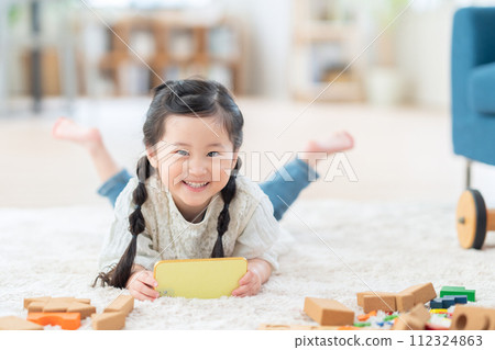 girl playing with smartphone in living room girl playing with smartphone in living room 112324863