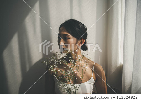 一個女人站在窗邊,草叢朦朧 一個女人站在窗邊,草叢朦朧 112324922