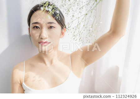 A woman standing by the window with a hazy grass 112324926
