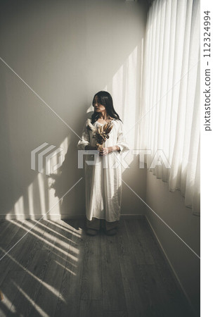 站在窗邊拿著花的女人 站在窗邊拿著花的女人 112324994