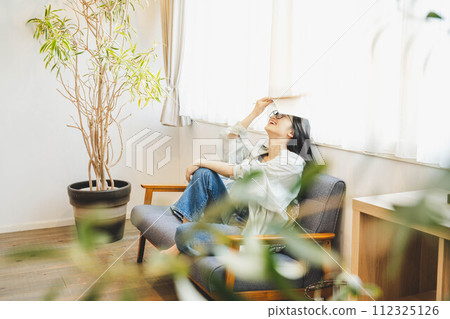 Woman taking a reading break on the sofa Woman taking a reading break on the sofa 112325126