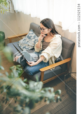 A woman teleworking on the sofa 112325154