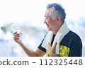 Senior man hydrating at the gym 112325448