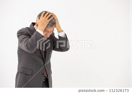 Senior man holding his head in business 112326173