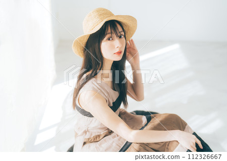 Woman with long hair wearing a straw hat 112326667